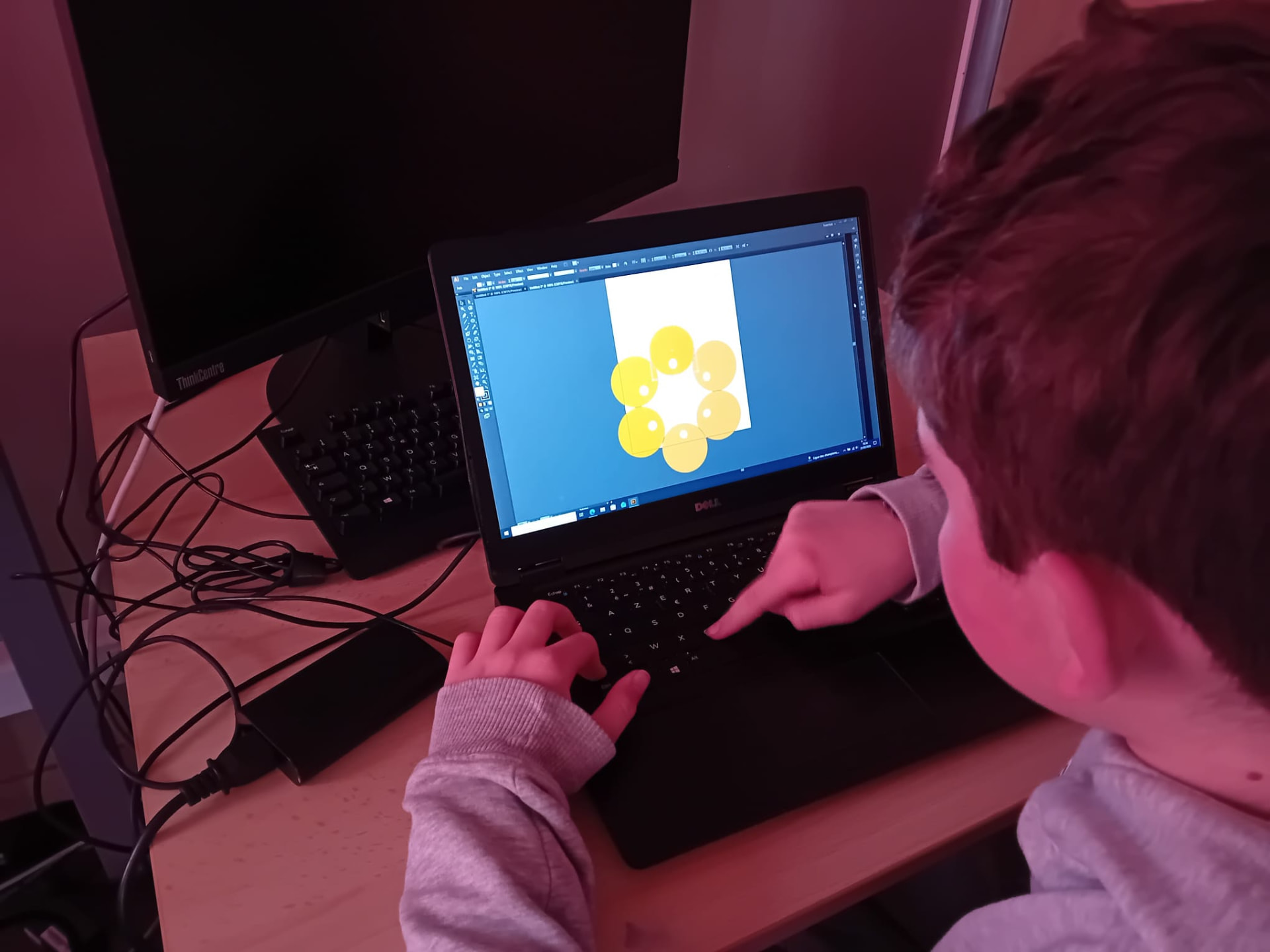 Un enfant réalise un dessin vectoriel sur ordinateur
